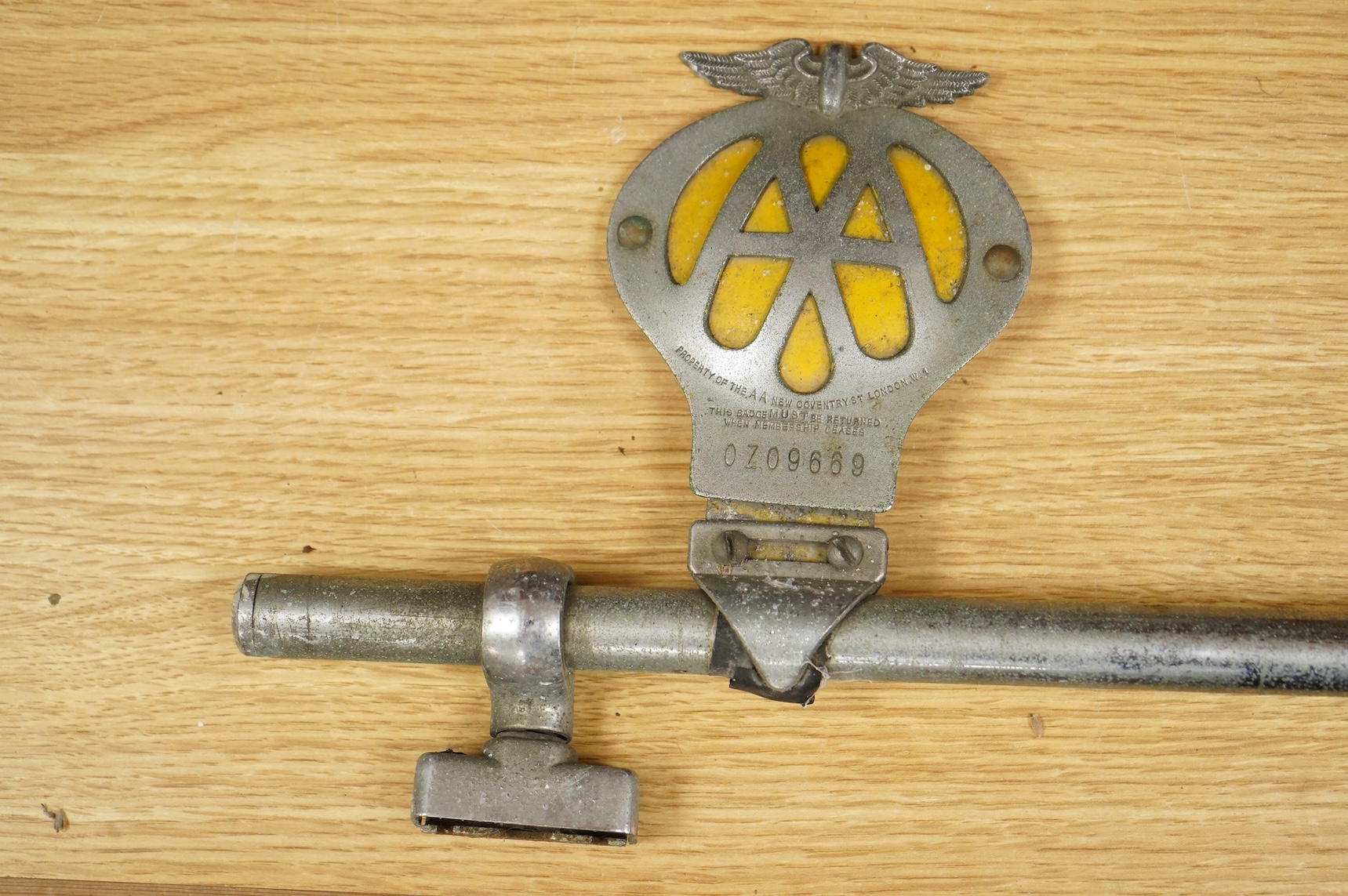 Three car badges to include RAC and AA, mounted on a bar, 67cm in length